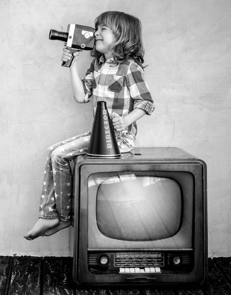 Child playing with cardboard box TV. Kid having fun at home. Communication concept